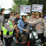 Polwan Polda Bali dan Jajarannya Bagikan Bunga Mawar dan Helm Gratis