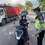 Satlantas Polres Badung Bagikan Masker Kepada Pengendara Motor