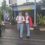 Hindari Kecelakaan Unit Lantas Polsek Kuta Utara Sebrangkan Anak-Anak Sekolah