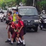 Personel Polantas Bantu Seberangkan Anak Sekolah