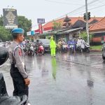 Di Guyur Hujan Personil Lalu Lintas Polsek Kuta Utara Tetap Atur Arus Lalin.