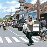 Bhabinkamtibmas Kamasan Amankan Prosesi Ngaben Warga.